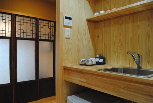 een keuken met een wastafel en een houten aanrecht bij NARAigoto EENA HOUSE in Nara