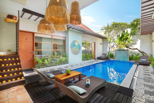 a villa with a swimming pool and a house at The Vie Villa in Legian