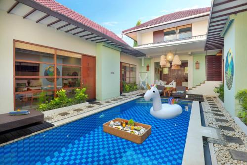 a pool in the backyard of a house with a pool noodle in a unicorn at The Vie Villa in Legian