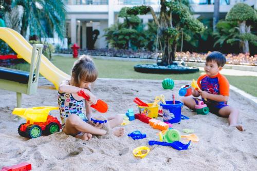 two children playing in the sand at a playground at FuramaXclusive Ocean Beach Seminyak Bali in Legian