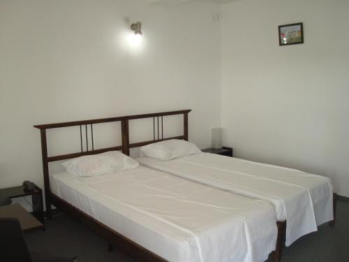 a bedroom with a large bed with white sheets at Pension Oasis in Costinesti