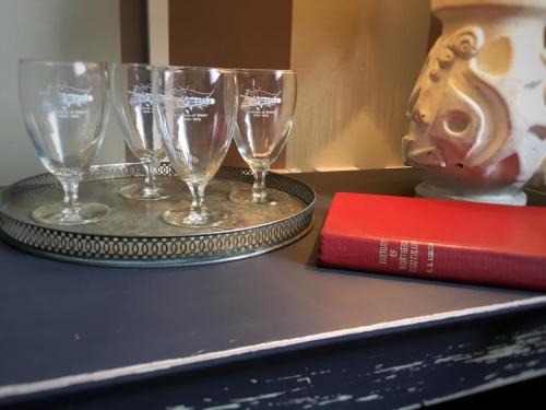 three wine glasses on a tray next to a book at Royal Mail Hotel in Lumsden