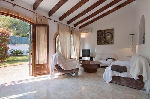 a large living room with a bed and a chair at Villa Escocia in Jávea