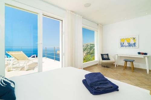 a bedroom with a bed and a view of the ocean at Villa Bombon in Jávea