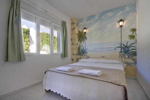 a bedroom with a bed with a painting on the wall at Villa Cora in Jávea