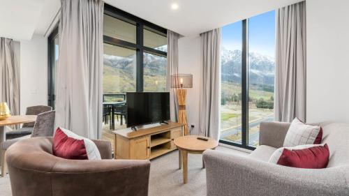a living room with two chairs and a television at Remarkables Garden Apartment 305 in Queenstown