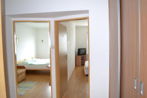 a bedroom with a door leading to a room with a bed at Privat Julia in Vrbov