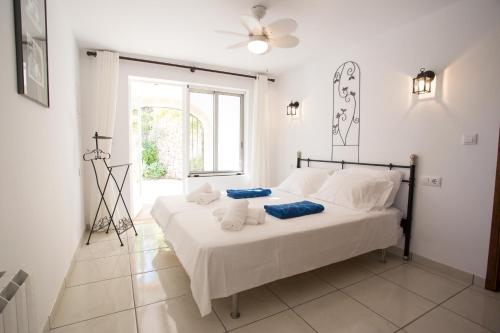 a white bedroom with a bed with towels on it at Casa Nana in Jávea