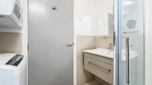 a white bathroom with a sink and a shower at Remarkables Garden Apartment 305 in Queenstown