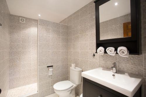 bagno con servizi igienici, lavandino e specchio di Casa Nana a Jávea