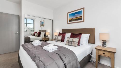 a bedroom with a large bed with towels on it at Remarkables Garden Apartment 305 in Queenstown