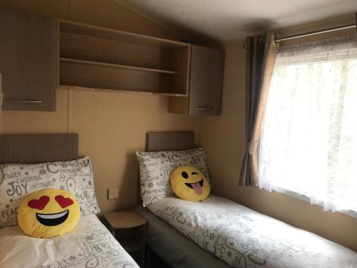 two beds with hello kitty pillows in a bedroom at Poppy at Oakdene Forest Park in Ringwood