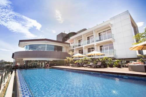 a building with a swimming pool in front of a building at Grandia Hotel in Bandung
