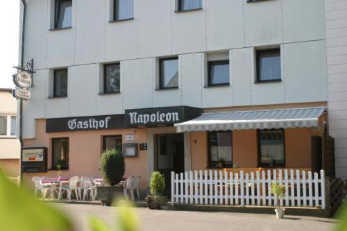 un edificio con una recinzione bianca di fronte a un ristorante di Gasthof Napoleon a Selbitz