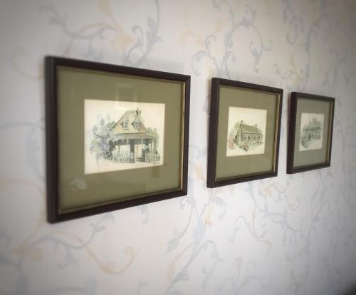 three framed pictures of a house on a wall at Royal Mail Hotel in Lumsden