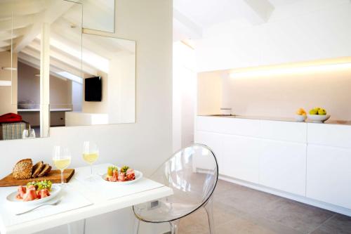 a white kitchen with a white table and chairs at Best Western Plus Royal Superga Hotel in Cuneo