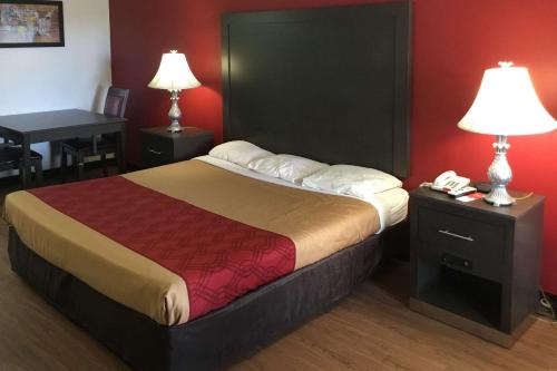 a bedroom with a bed and a desk with a telephone at Econo Lodge Ruther Glen in Ruther Glen