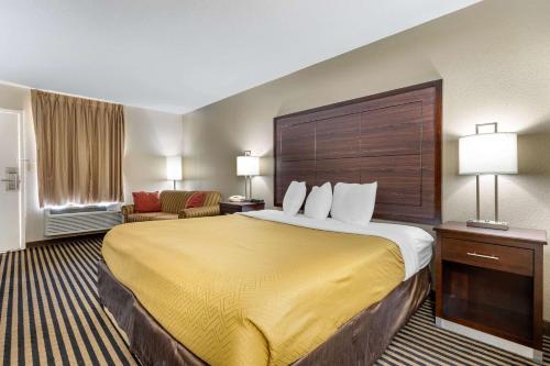 a hotel room with a large bed with a yellow blanket at Econo Lodge in Florence