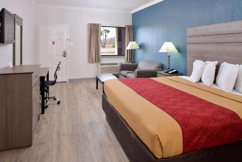 een hotelkamer met een groot bed en een bureau bij Econo Lodge Inn & Suites Port Arthur near Sabine Pass in Port Arthur