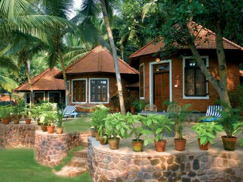 a house with chairs and plants in front of it at Soma Manaltheeram Ayurveda BeachVillage in Kovalam