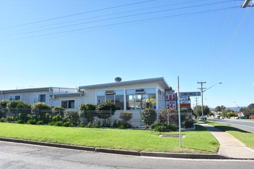 a house on the corner of a street with a sign at Hillview Motel in Goulburn