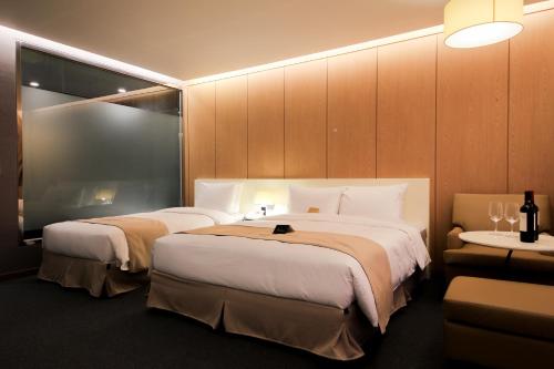a hotel room with two beds and two tables at Incheon Stay Hotel in Incheon