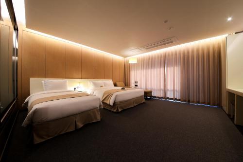 a hotel room with two beds and a window at Incheon Stay Hotel in Incheon
