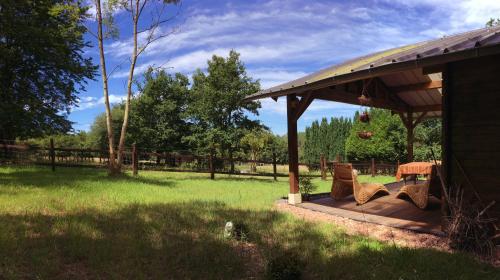 a gazebo with chairs and a table in a field at les Chevreuils in Saint-Sylvestre-de-Cormeilles