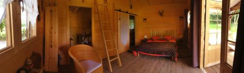 a bedroom with a bed in a wooden house at les Chevreuils in Saint-Sylvestre-de-Cormeilles