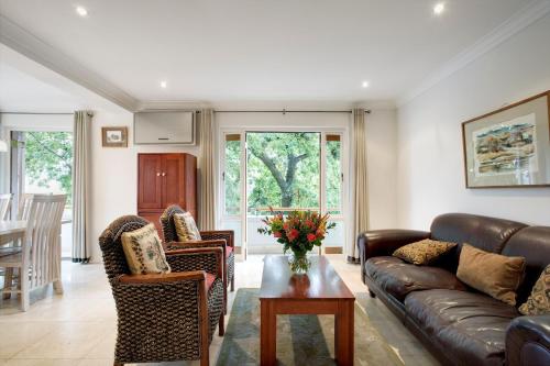 a living room with a couch and chairs and a table at The Stellenbosch Hotel in Stellenbosch