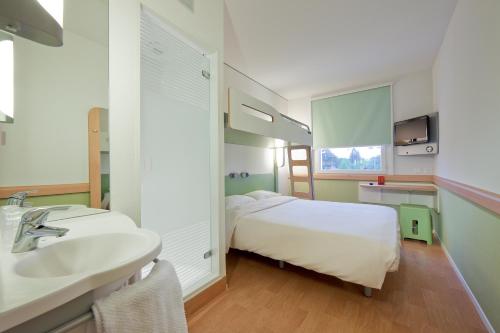 Habitación con baño con cama y lavabo. en ibis budget Lugano Paradiso, en Lugano