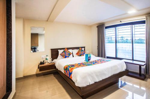 a bedroom with a large bed and a large window at FabExpress Silver Lake in Mumbai
