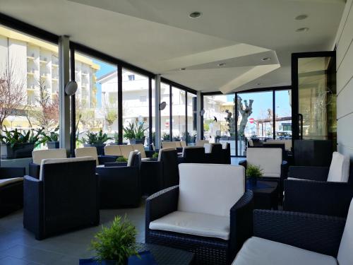 a restaurant with chairs and tables and windows at Hotel Tiglio in Rimini