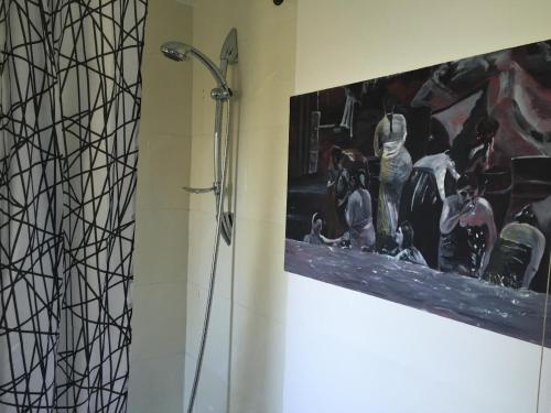 a shower in a bathroom with a painting on the wall at Spacious 3 Bedroom Apartment in St. Albans