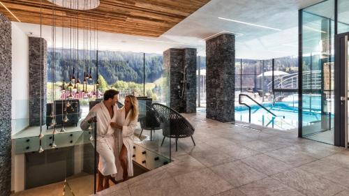 a man and woman standing at a bar in a hotel lobby at Hotel Interski in Santa Cristina Gherdëina