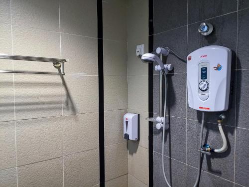 eine Dusche im Bad mit einem Telefon an der Wand in der Unterkunft Hotel Centre Point Tampin in Malakka