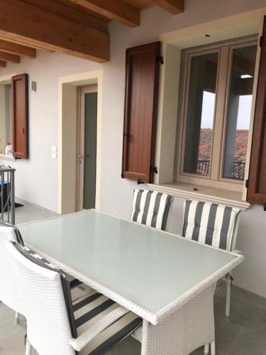 a white table and two chairs on a patio at "Country House il Brolo" in Polpenazze del Garda