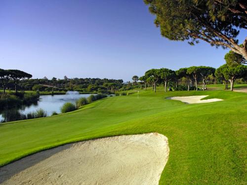 a golf course with a view of a river and a green at Ria Park Garden Hotel in Vale do Lobo