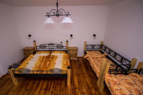 two beds in a room with wooden floors at Rozboudovec in Křemže