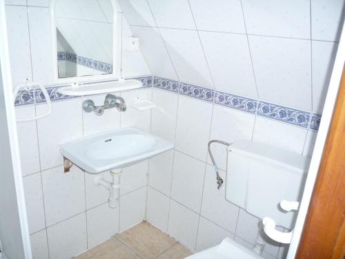 a white bathroom with a sink and a toilet at OW Gromada Pod Topolami in Międzyzdroje