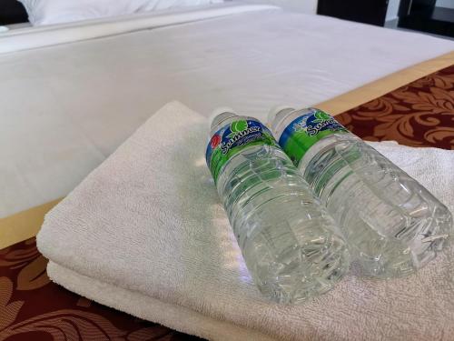 two empty water bottles sitting on top of a towel at Hotel Centre Point Tampin in Melaka
