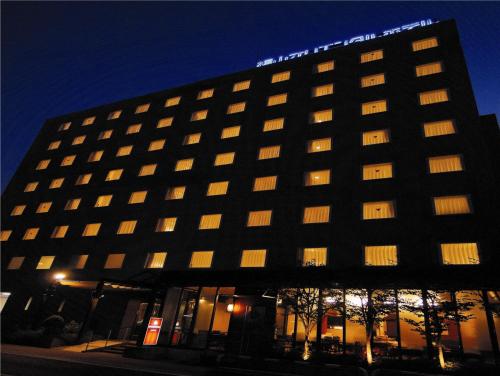 a large hotel building with a sign on top of it at Fukuyama Oriental Hotel in Fukuyama