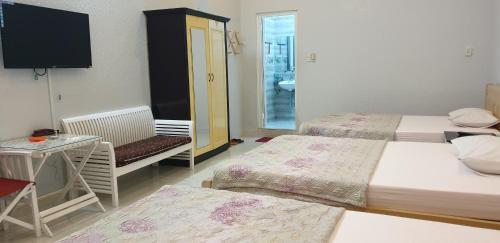 a hotel room with two beds and a television at Bac Huong Hotel in Kon Tum