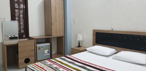 a bedroom with a bed and a table with a lamp at Bac Huong Hotel in Kon Tum