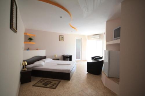 Una habitación de hotel con una cama y una sala de estar. en Vila Casa Leul, en Jupiter
