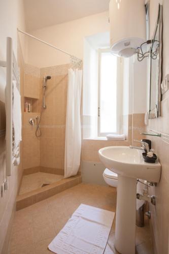 ein weißes Badezimmer mit Waschbecken und Dusche in der Unterkunft B&B Calamatta in Rom