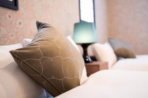 a pillow sitting on a bed in a bedroom at Kotonone Mai Suzu in Yufuin