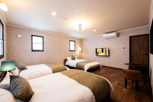 a hotel room with three beds in it at Kotonone Mai Suzu in Yufuin