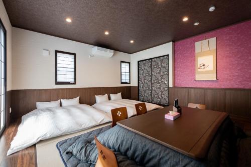 sypialnia z 2 łóżkami i stołem w obiekcie Kotonone Mai Suzu w mieście Yufu