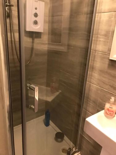 a shower with a glass door in a bathroom at Abbey Wood Station six Bedroom Self Contained House in Abbey Wood